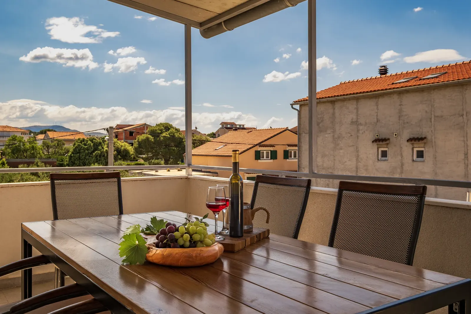 Terasa apartmana sa stolom i pogledom na okolicu