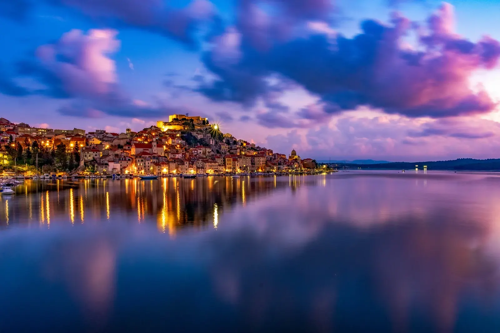 Šibenik u plavom satu s odrazima svjetla na moru